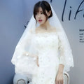 White lace wedding gown with off-the-shoulder sleeves paired with korean lace petal bridal veil featuring floral appliqués