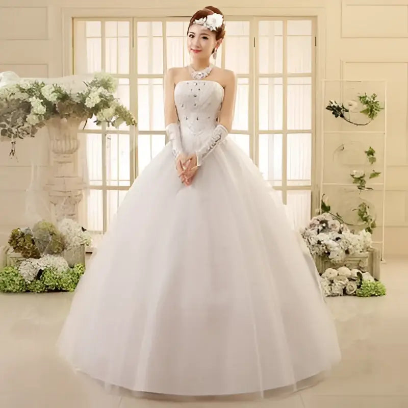 White strapless lace wedding dress with intricate beading and lace detailing featuring a strapless bodice paired design