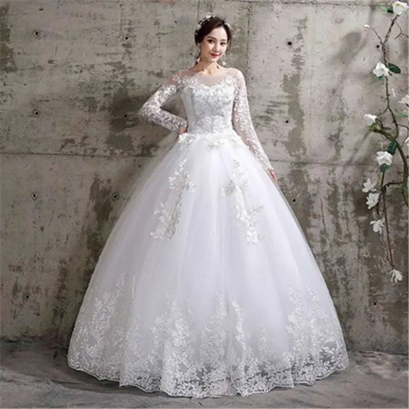 A white floor length wedding dress with intricate lace detailing and beaded embellishments on the bodice and skirt