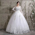 A white lace and beaded floor length wedding dress with long sleeves and a voluminous tulle skirt featuring intricate lace detailing
