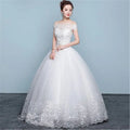 Elegant white off-the-shoulder wedding gown with intricate lace detailing and beaded floor length tulle skirt