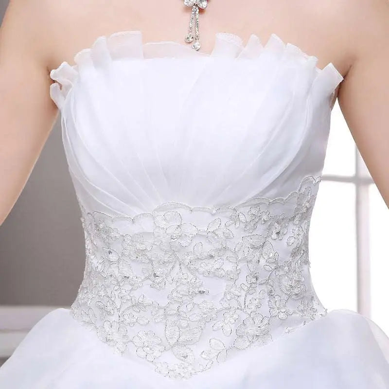 White strapless bride wedding dress with ruffled neckline and intricate silver lace beaded tulle bride bodice detailing