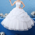 A white strapless beaded tulle bride wedding dress with a fitted bodice and layered tulle skirts for brides