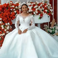 White lace ball gown wedding dress with long sheer sleeves and a voluminous skirt perfect for bridal wear