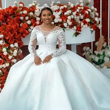 White lace ball gown wedding dress with long sheer sleeves and a voluminous skirt perfect for bridal wear