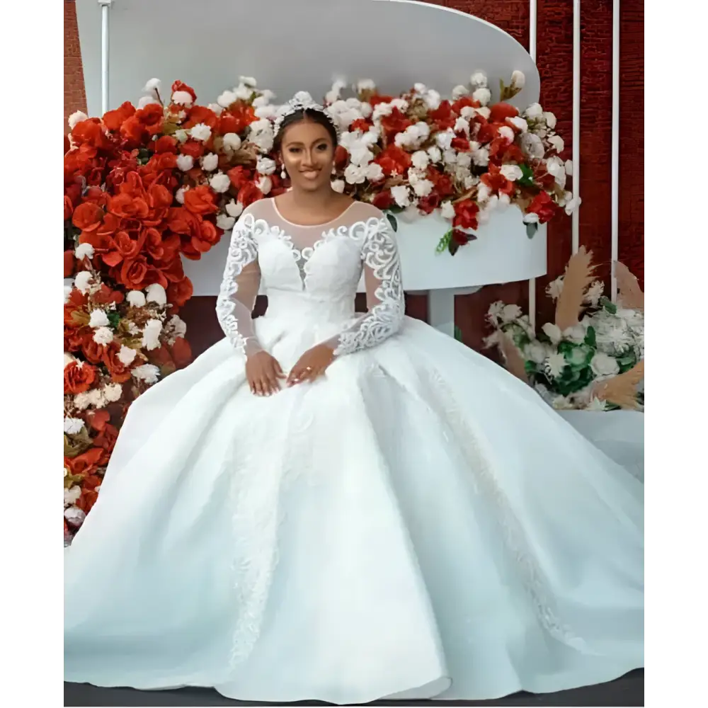 White lace ball gown wedding dress with long sheer lace sleeves and intricate beaded detailing on bodice and skirt