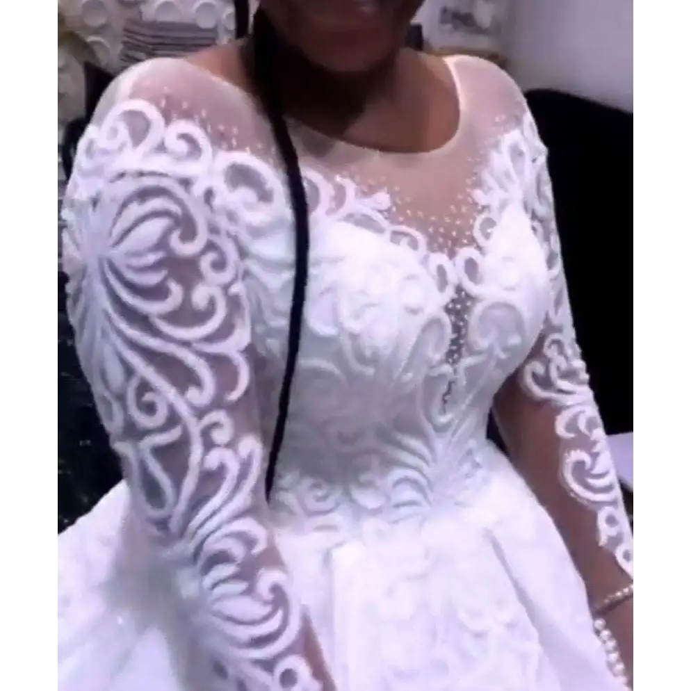 A white lace sleeve wedding gown with intricate floral embroidery and plus size illusion sheer long sleeves
