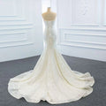 A white lace mermaid wedding dress with a fitted bodice featuring two fishtail train for elegant bridal wear