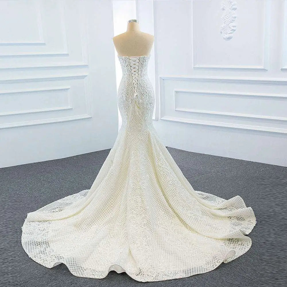 A white lace mermaid wedding dress with a fitted bodice featuring two fishtail train for elegant bridal wear