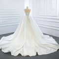 Back view of a white satin lace mermaid wedding dress with corseted back and two fishtail train detailing