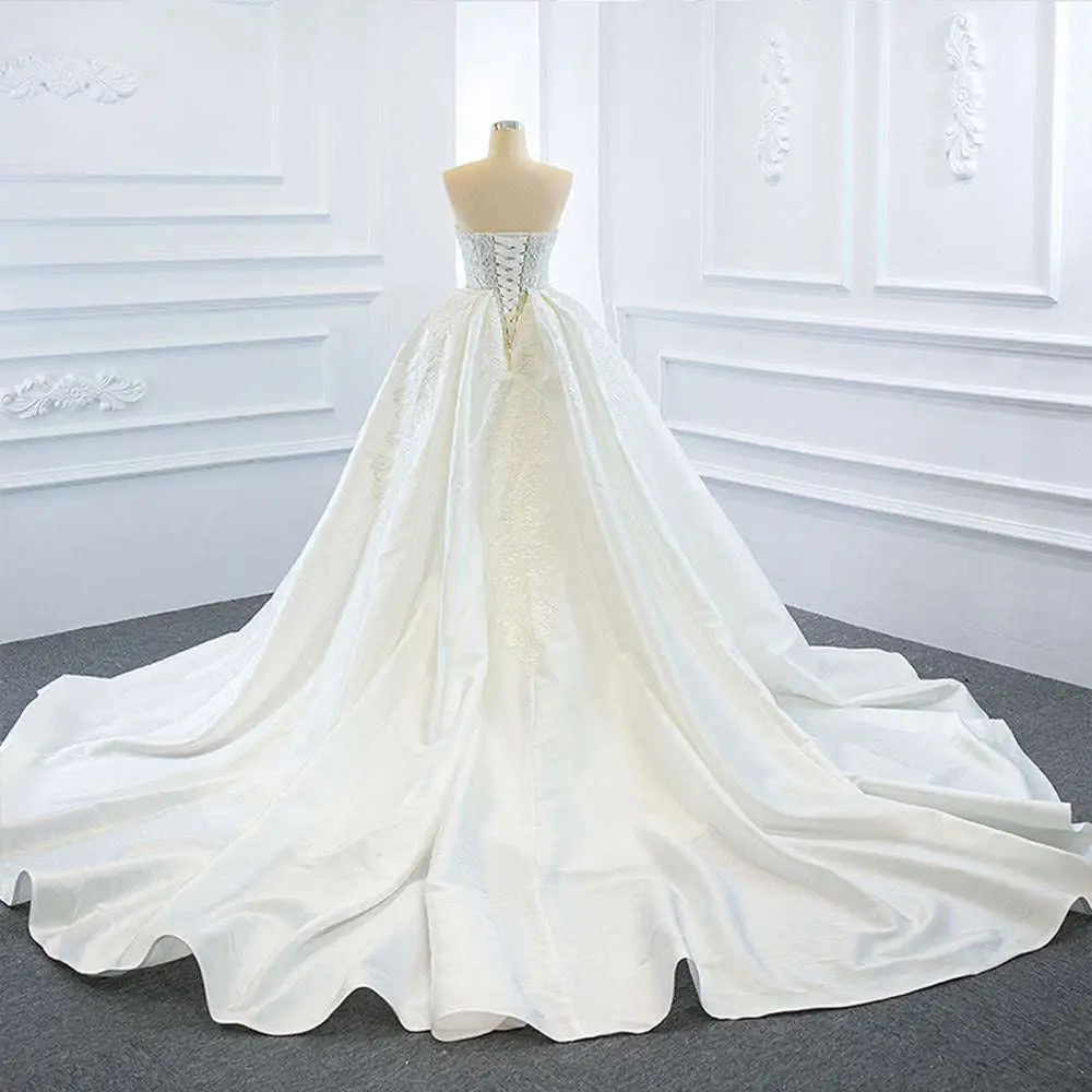 Back view of a white satin lace mermaid wedding dress with corseted back and two fishtail train detailing