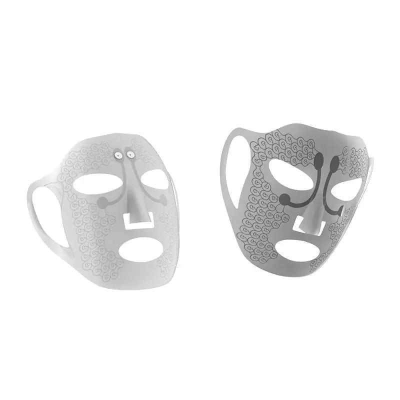 Two metallic silver electric facial massage masks with intricate swirling lace patterns and stylized facial features