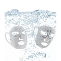 Two translucent gray facial massage masks with intricate swirling lace texture float underwater for electric facial massage
