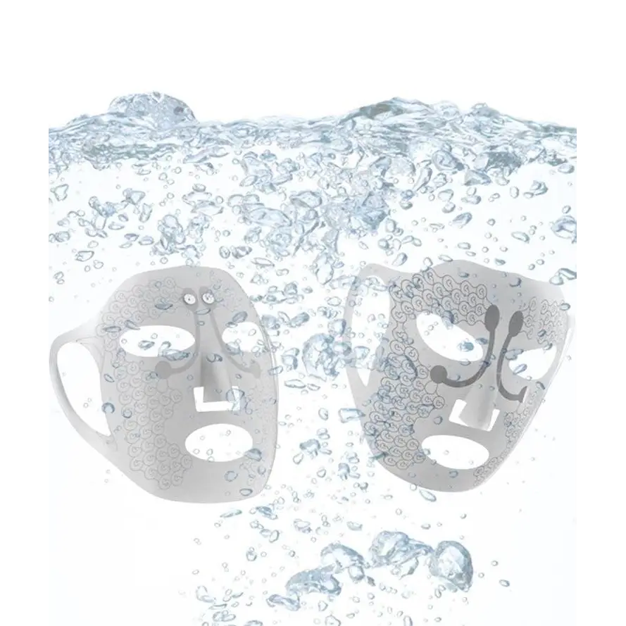 Two translucent gray facial massage masks with intricate swirling lace texture float underwater for electric facial massage