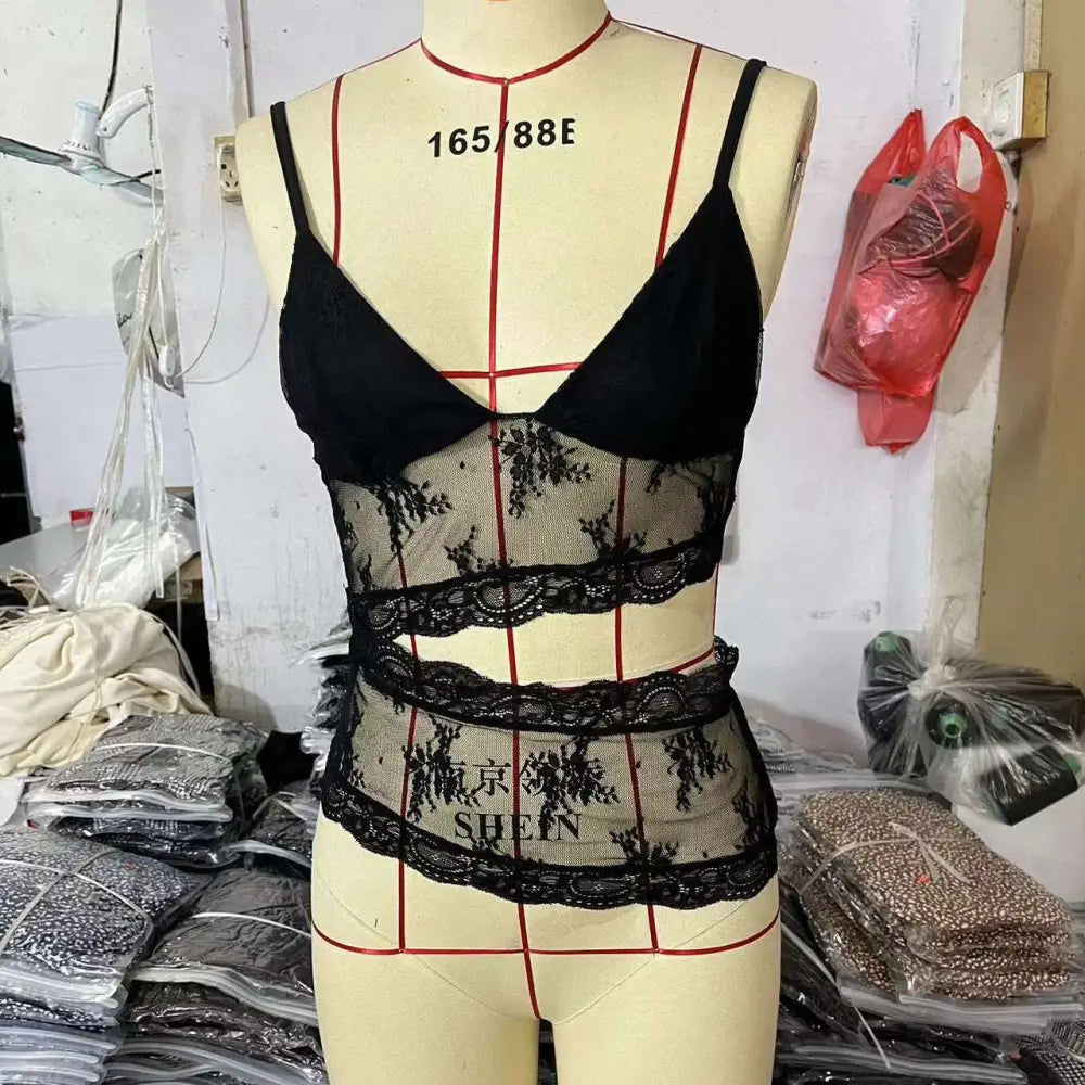 Black lace stitched backless small sling v neck tank top with sheer mesh panels and floral embroidery on mannequin