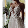 A delicate ivory lace strap backless wedding dress with a plunging backless v neck and intricate floral embroidery