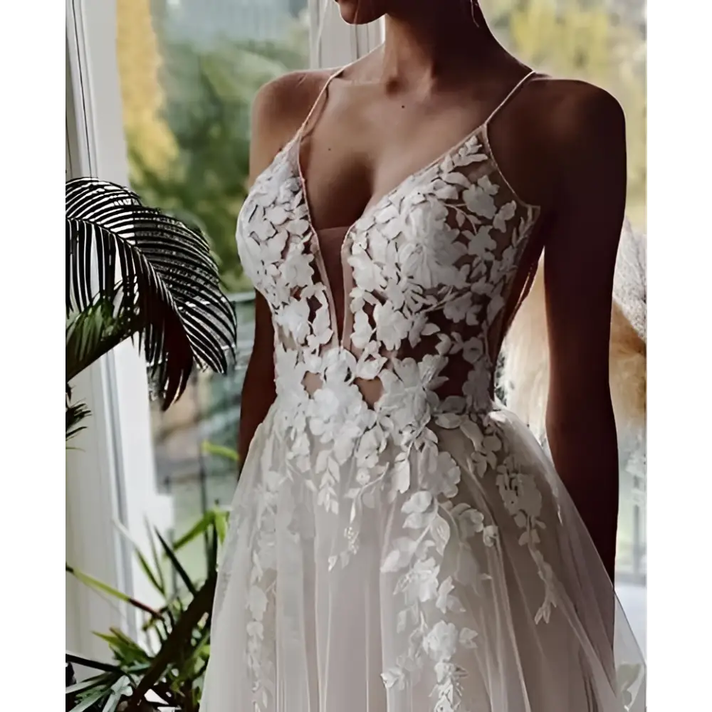 Delicate ivory lace strap backless v neck wedding dress with intricate floral embroidery and flowing white wedding style