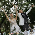 White lace wedding dress with floral embellishments and fitted bodice for summer couple photo shoot