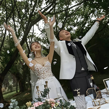 White lace wedding dress with floral embellishments and fitted bodice for summer couple photo shoot