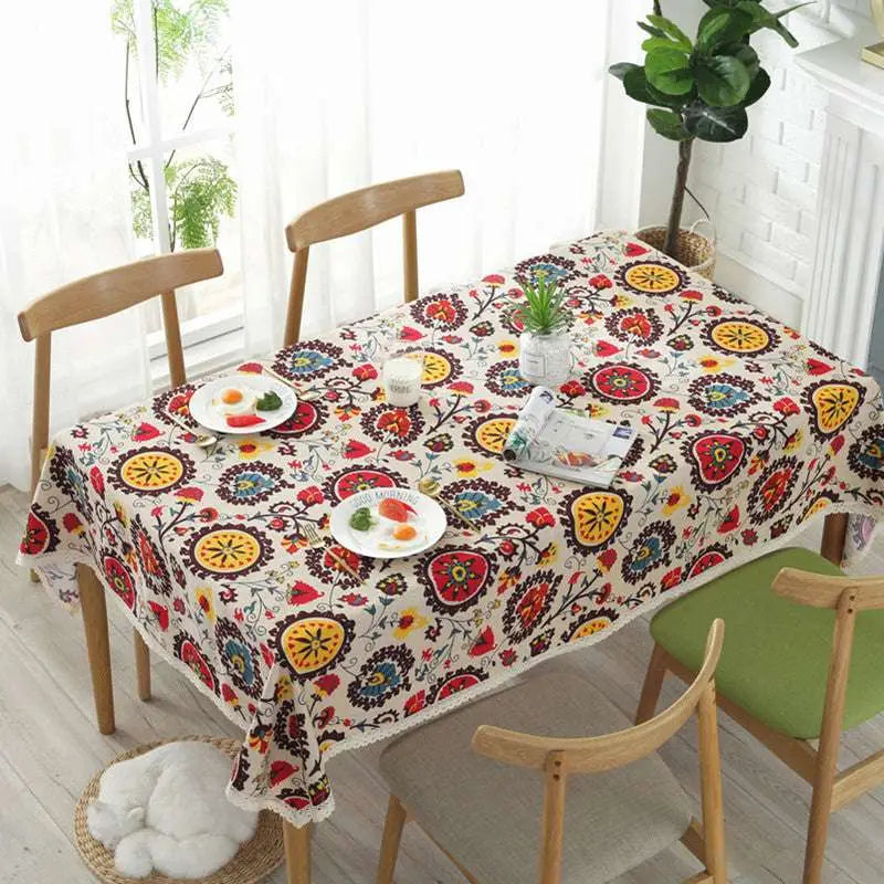 A vibrant linen tablecloth with lace trim featuring sunflower cotton linen floral motifs in red yellow blue and black