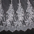 Delicate silver lace wedding dress fabric with intricate floral and vine patterns and subtle sequins on a trailing floral bridal veil