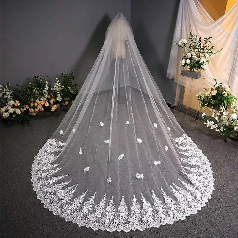 A delicate white lace wedding dress veil with intricate trailing floral bridal embroidery and scalloped edge detailing