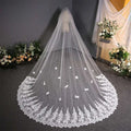 A delicate white lace wedding dress veil with intricate trailing floral bridal embroidery and scalloped edge detailing