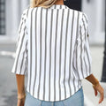 A woman wears a ladies fashionable printed striped v-neck neck shirt in white with black vertical stripes and three-quarter sleeves