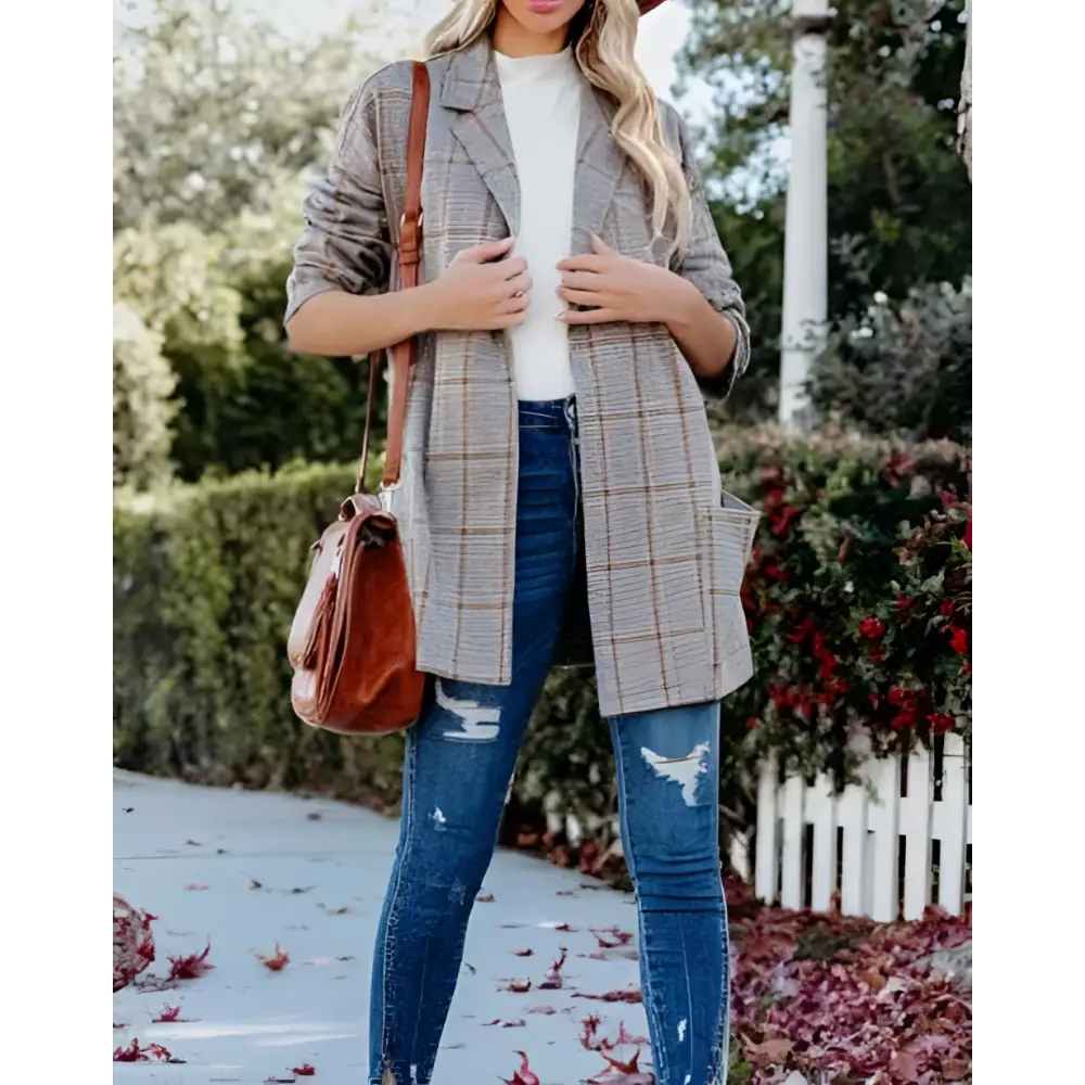 A woman wearing a gray and brown ladies plaid printed open collar blazer jacket with a classic long coat design