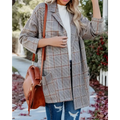 A woman wearing a gray and brown ladies plaid printed open collar blazer jacket with a classic long coat design