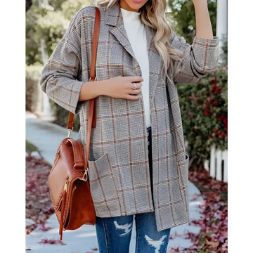 A woman wearing a gray and brown ladies plaid printed open collar blazer jacket with a classic long coat design