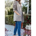 A woman wears a muted beige and brown ladies plaid printed open collar blazer with rolled-up sleeves