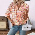 White quilted crossbody bag with gold-tone chain strap and clasp paired with cream-colored lantern sleeve floral print v neck blouse