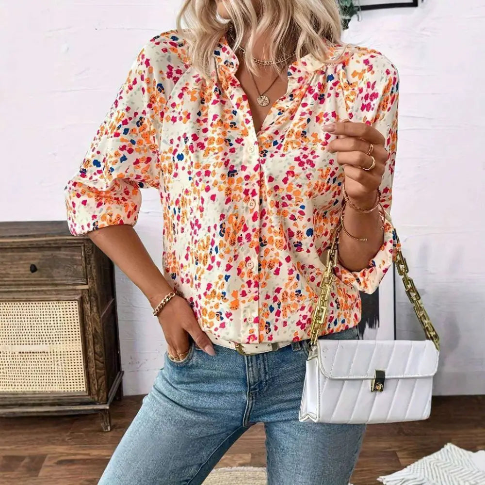White quilted crossbody bag with gold-tone chain strap and clasp paired with cream-colored lantern sleeve floral print v neck blouse