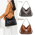 A sleek black luxury women leather hobo bag with large capacity tassel details and a detachable strap