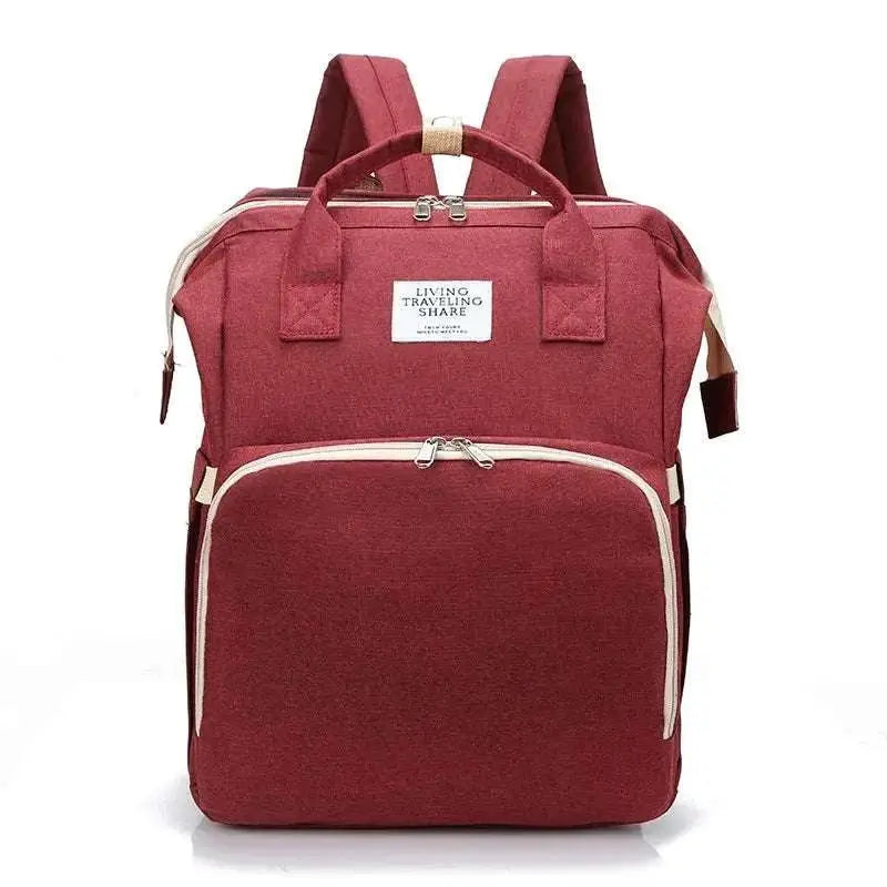 A maroon fabric large capacity mommy bag with beige trim and a white living traveling share label for baby essentials