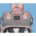 Pink and gray large capacity mommy bag with black land label front for baby essentials backpack use