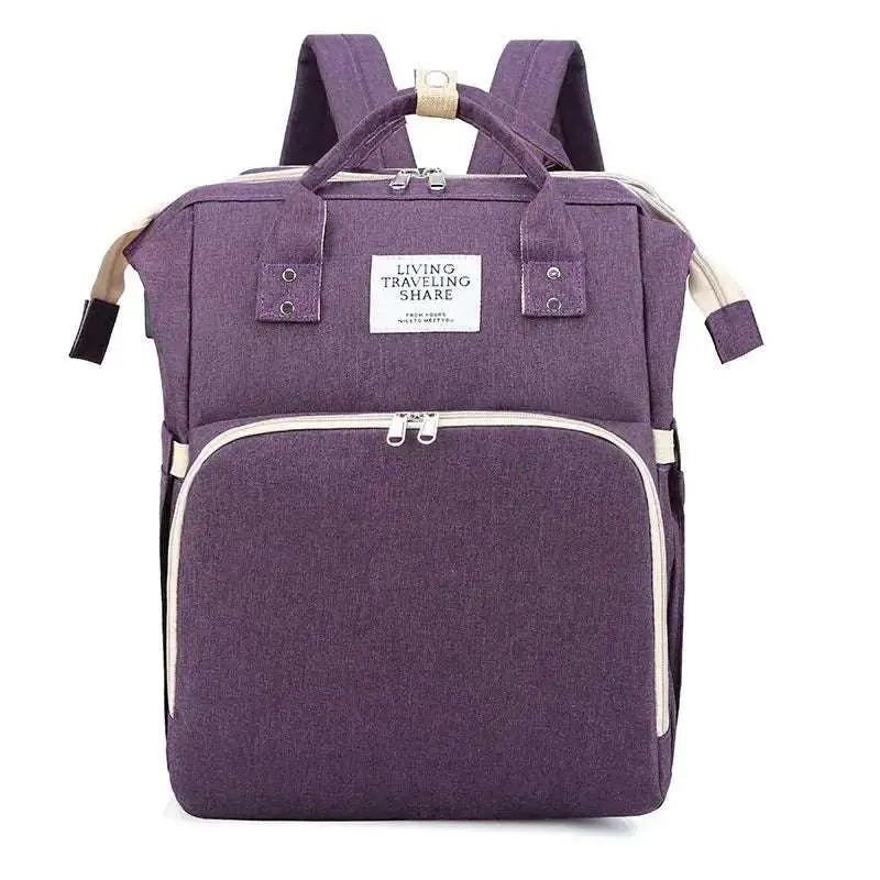 Large capacity mommy bag in purple fabric with beige zipper pulls and trim featuring front pocket and top handle
