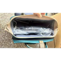 Teal and beige large capacity mommy bag with mesh-lined interior holding a plastic-wrapped item for baby essentials