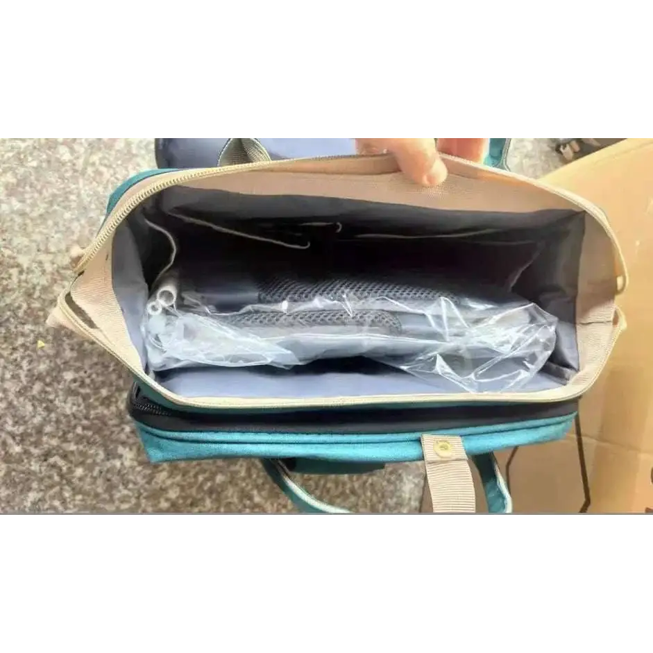 Teal and beige large capacity mommy bag with mesh-lined interior holding a plastic-wrapped item for baby essentials