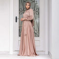 A flowing dusty rose large hem satin long sleeve abaya with matching hijab showcasing fashion large hem design