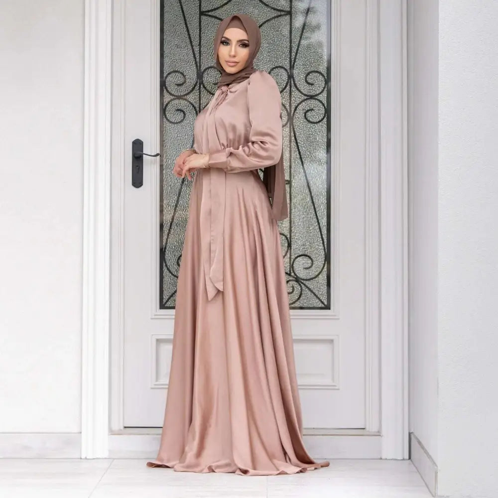 A flowing dusty rose large hem satin long sleeve abaya with matching hijab showcasing fashion large hem design