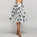 A white slim fit a-line skirt with large black polka dots featuring striped interiors worn by a model