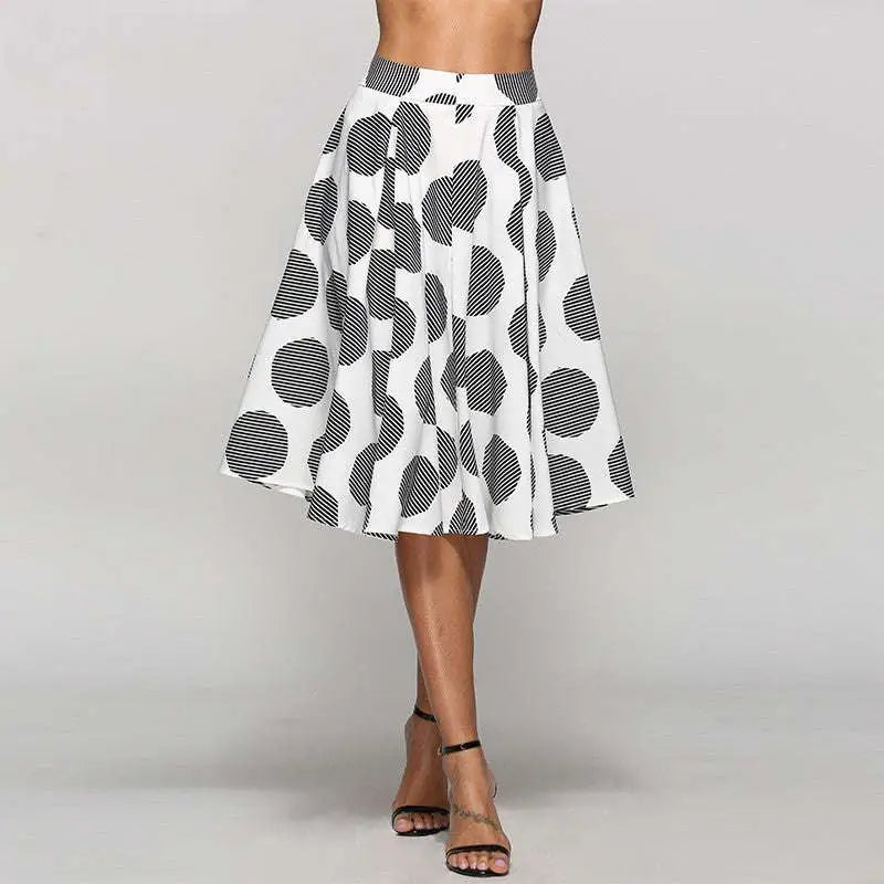 A white slim fit a-line skirt with large black polka dots featuring striped interiors worn by a model