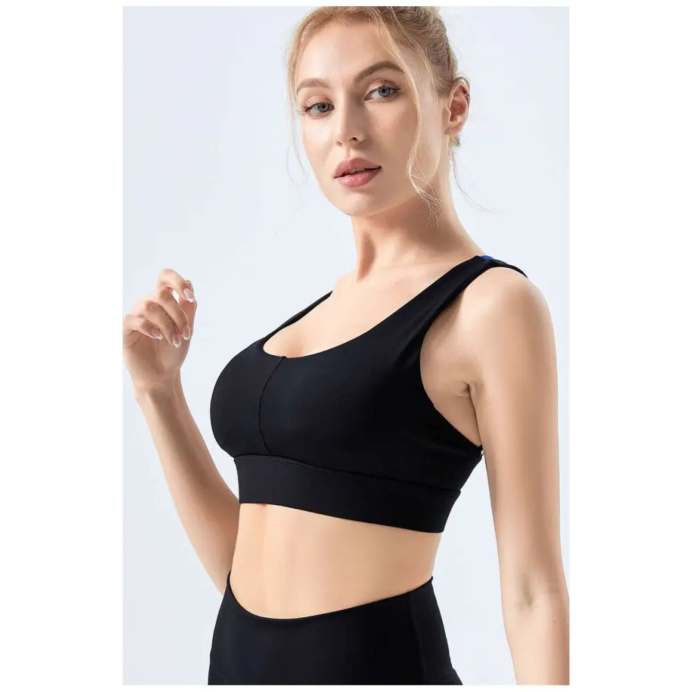 Black sports bra with supportive design and sleek form-fitting silhouette made from nylon as a seamless fitness bra