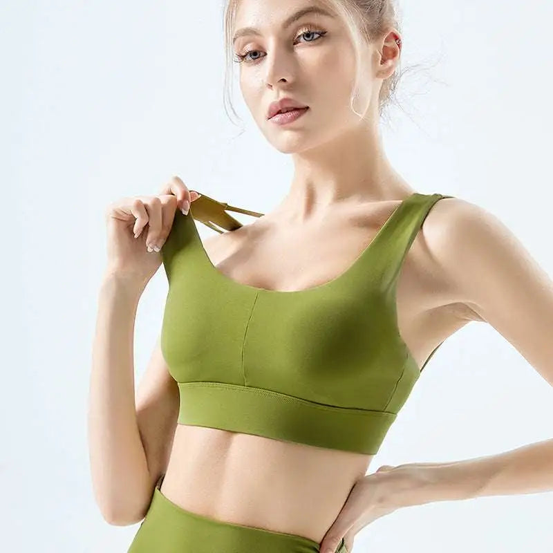 Olive green seamless fitness bra with nylon fabric, wide supportive band, and thin adjustable straps for workout use