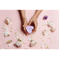 A lavender heart shower steamer with speckled texture held in hands against pink background for shower steamers gift