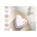 A soft lavender heart shower steamer with delicate dried flower petals in a shower steamers gift set