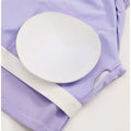 A white padded insert with a textured surface on the lavender ribbed fabric of a breathable running sports bra