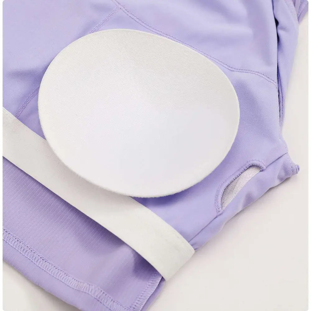 A white padded insert with a textured surface on the lavender ribbed fabric of a breathable running sports bra